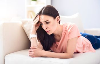 Worried woman lying on the bed