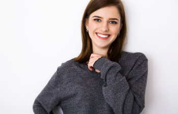 smiling brunette in a gray sweater